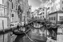 Beautiful Black And White View Of A Typical Venetian Canal, Fondamenta Dei Preti, Venice, Italy, With A Couple On A Gondola, Taking Pictures And Making Video