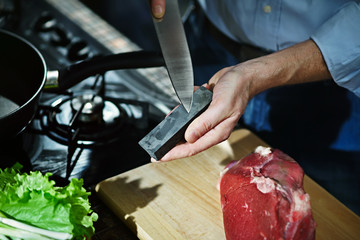 Wall Mural - Man sharpens kitchen knife