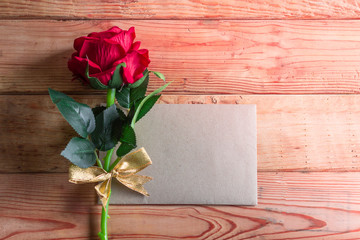 Paper for your text and small red hearts, rose on old wood backg