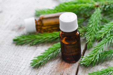 Two bottles of essential oil and fir branches. Aromatherapy and spa products