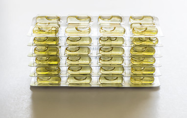 yellow capsule pills and package use in pharmaceutical manufacturing, drug, medicine, garlic oil, fi