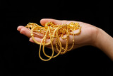 Fototapeta Do akwarium - Hand Holding Expensive Gold Jewelry necklace and bracelet