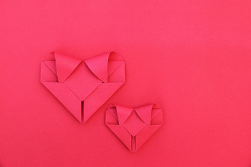 Poster - two folding red paper hearts on red for pattern and background