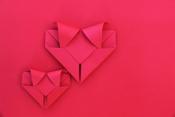 Poster - two folding red paper hearts on red for pattern and background