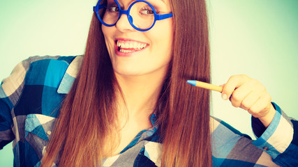 Wall Mural - Happy nerdy woman in glasses holding pen