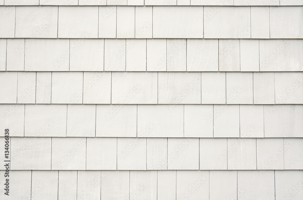 Neutral white or tan siding on a house or building. Straight parallel lines. Outdoor siding with highlights.. Roofing or construction material. - obrazy, fototapety, plakaty 