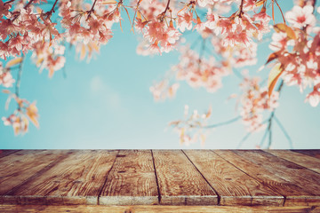 Wall Mural - top of wood table with pink cherry blossom flower (sakura) on sky background in spring season - empt
