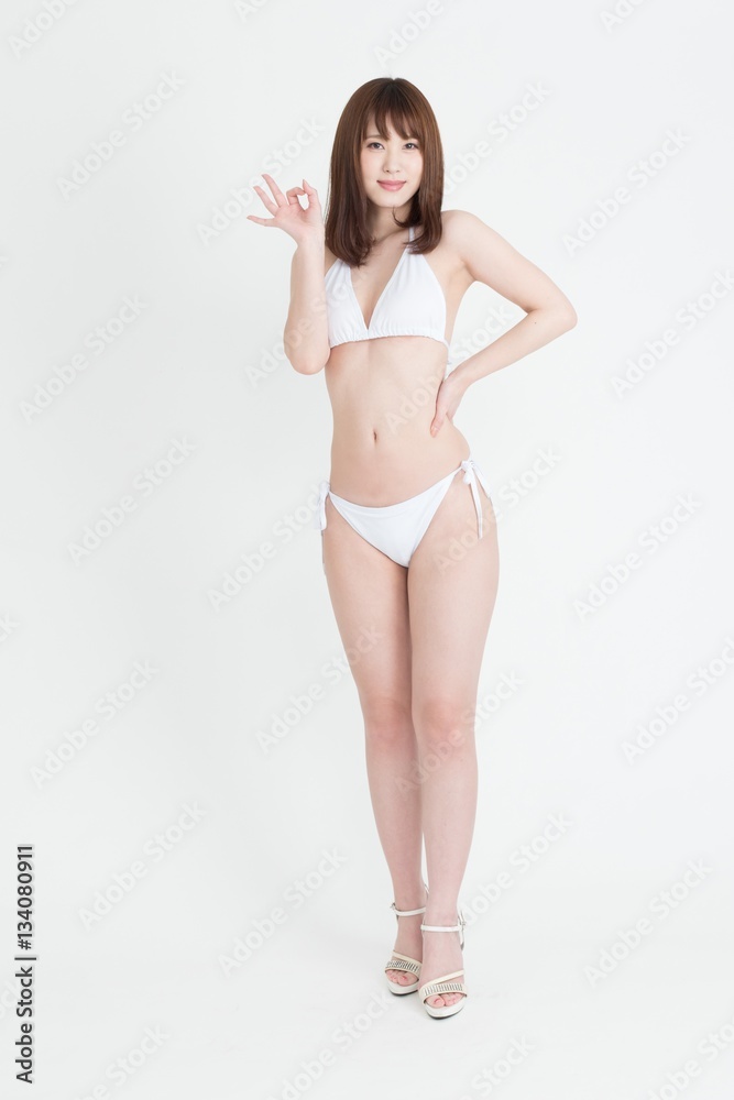 白いビキニの水着を着た若い女性。スタジオ撮影、白背景。 の Stock 