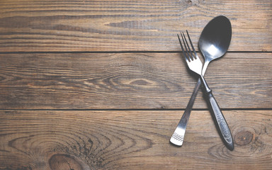 Spoon and fork on wooden table.
