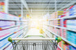 © nonnie192 - Supermarket aisle with empty green shopping cart