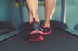 Female muscular feet in sneakers running on the treadmill at the gym. Concept for fitness, exercising and healthy lifestyle.