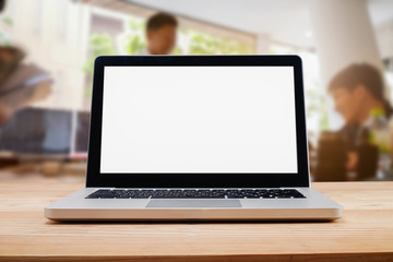 Computer with blank screen on table with blur background. Technology concept.