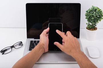 Wall Mural - Young man working using mobile phone and laptop