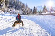 Cheerful Girl Riding A Sled Downhill, Snow, Sunny Winter Landscape