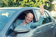 © hbrh - Handsome young business man raised hand out of the window of the car. Italy country car trip