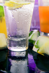 Wall Mural - Different kinds of fresh lemonades in glasses on light background