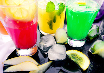 Wall Mural - Different kinds of fresh lemonades in glasses on light background