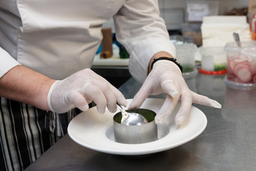 Chef is serving dish with metal ring