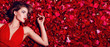 Valentine's Day. Loving girl. The girl in a red dress lying on the floor in the petals of red roses. Background of red rose petals. Red lipstick on the lips from the beautiful girl.