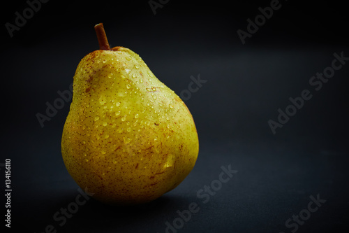 Fotografia Fresh yellow peer on black background