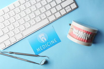 Canvas Print - Business card, keyboard and dental tools on blue background. Medical service concept