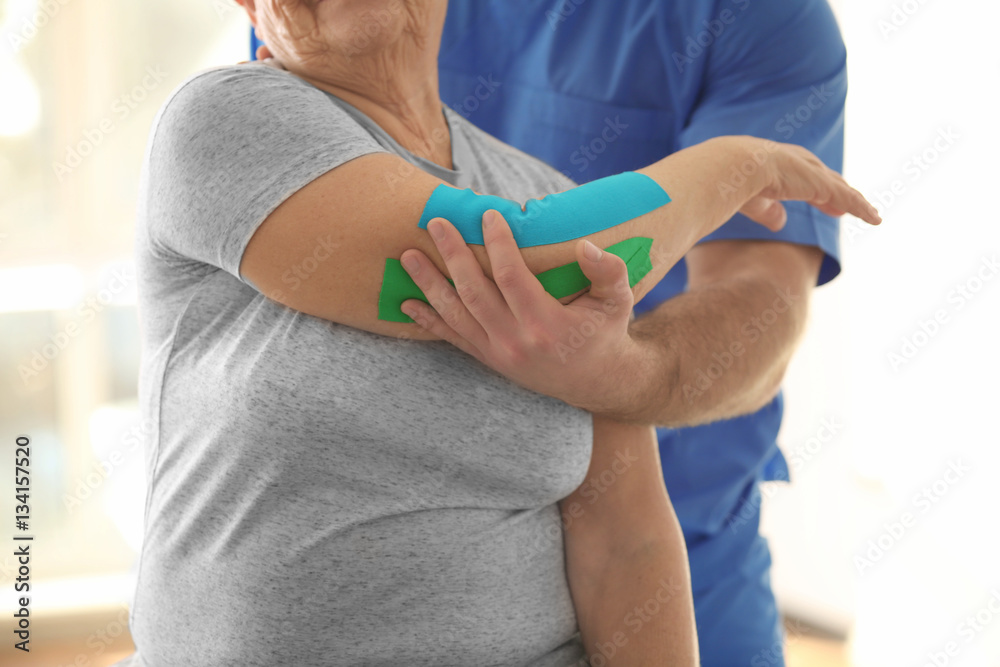 Physiotherapist working with elderly patient in clinic