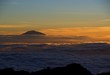 Mt Meru peeking through the clouds at sunset from Mt Kilimanjaro