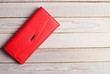 © splitov27 - Red purse clutch on a white wooden table.