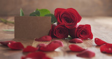 Three Red Roses With Empty Paper Card On Old Wood Table, 4k Photo