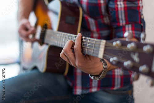 Fotografija Accord chord, Close up of mens hands playing an acoustic guitar