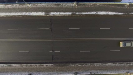 Canvas Print - Aerial - Cars driving on a two-lane road through a snowy landscape. 4k video