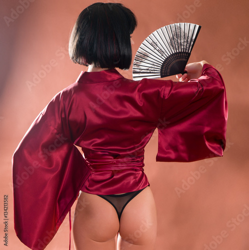 Cuadros en Lienzo sexy geisha in Japanese red kimono with a fan. Back view female