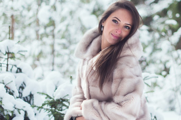 Beautiful winter portrait of young woman in park.