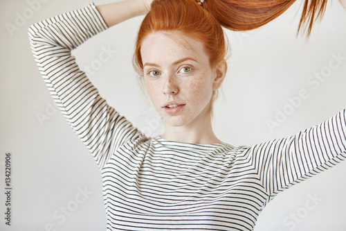 Pretty Girl With Green Eyes And Freckles Smiling Joyfully Tying