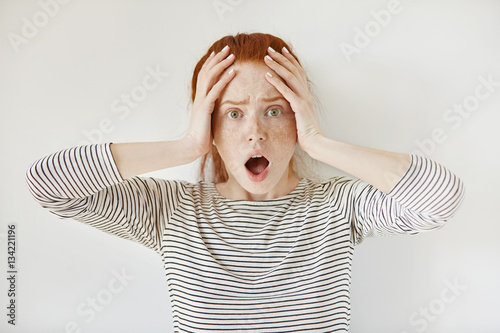 Fotografía Close up portrait of puzzled and scared redhead Caucasian student girl wearing s