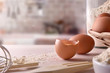 © Davizro Photography - Fresh eggs and utensils on wooden bench with kitchen background