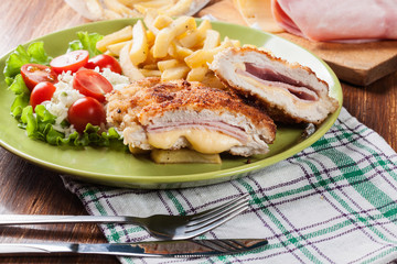 Wall Mural - Cutlet Cordon Bleu with pork loin served with French fries and salad