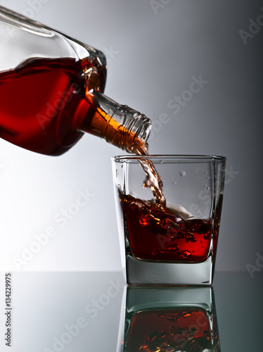 butelka-i-kieliszek-whisky-na-szklanym-stole