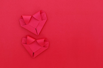 Poster - two folding red paper hearts on red for pattern and background