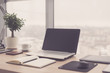 © undrey - Workplace with notebook laptop Comfortable work table in office windows and city view.