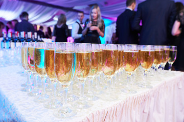 glasses with white sparkling wine in row at restaurant event