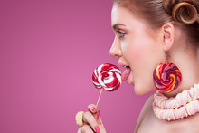 Attractive Woman With Lollipop In Hand On Pink Background