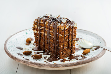 Wall Mural - Piece of chocolate Spartak cake on a table. Delicious sweet food on a beautiful plate. Close-up shot.