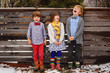 © RooM The Agency - Three happy children standing in front of a garden fence in snow, USA