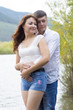 © sanchos303 - Lovers man and woman standing arm in arm by the river.