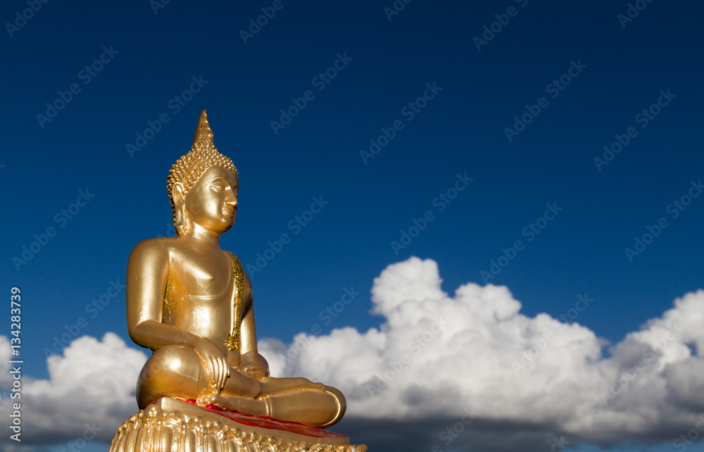 Gold Buddha statue floating on white clouds with deep blue sky ...