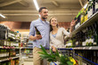 © Syda Productions - couple with wine and shopping cart at liquor store