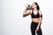 © Drobot Dean - Attractive woman with armband drinking water and listening to music