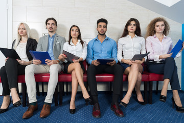 Canvas Print - Tired Candidates Wait For Job Interview, Mix Race Business People Sitting In Line Human Resources Hiring Vacancy Recruitment