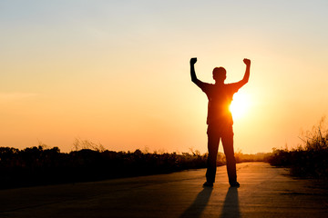 Poster - man standing on road at sunset background, silhouette